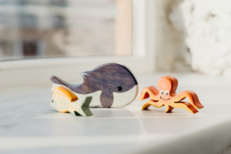 Adorable wooden sea animals including whale, fish, and octopus in daylight.
